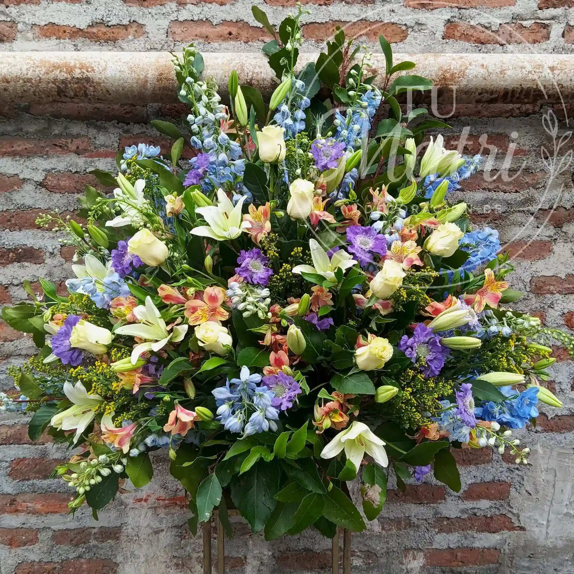 Arrimo floral de delphinium celeste y rosas blancas 4