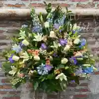 Arrimo floral de delphinium celeste y rosas blancas